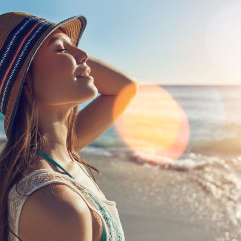 a lady on a beach in the sun after having skin treatments at sf aesthetics.