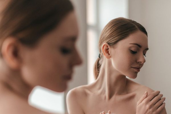 A lady in a mirror after having body treatments at SF Aesthetics, Northamptonshire.